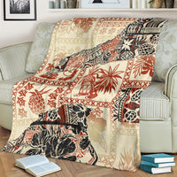 Beige aloha-style blanket with red and black tribal pattern, draped on couch