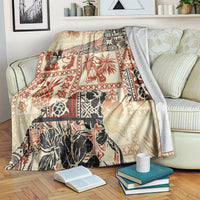 Beige blanket with red and black jungle tribal patchwork, folded over arm