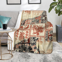 Beige decorative blanket with red and black tribal patchwork print, resting on rug