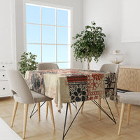 Beige tablecloth on dining table with tribal floral and animal pattern in black and red