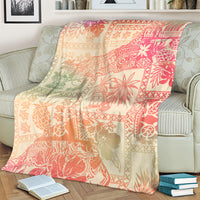 Pink ombre tropical patterned blanket, draped across couch with hibiscus and tiki designs