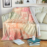 Pink ombre tropical blanket with floral patchwork, draped over couch arm and seat