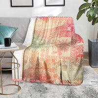 Pink ombre tropical patterned blanket, draped over sofa with palm and hibiscus motifs
