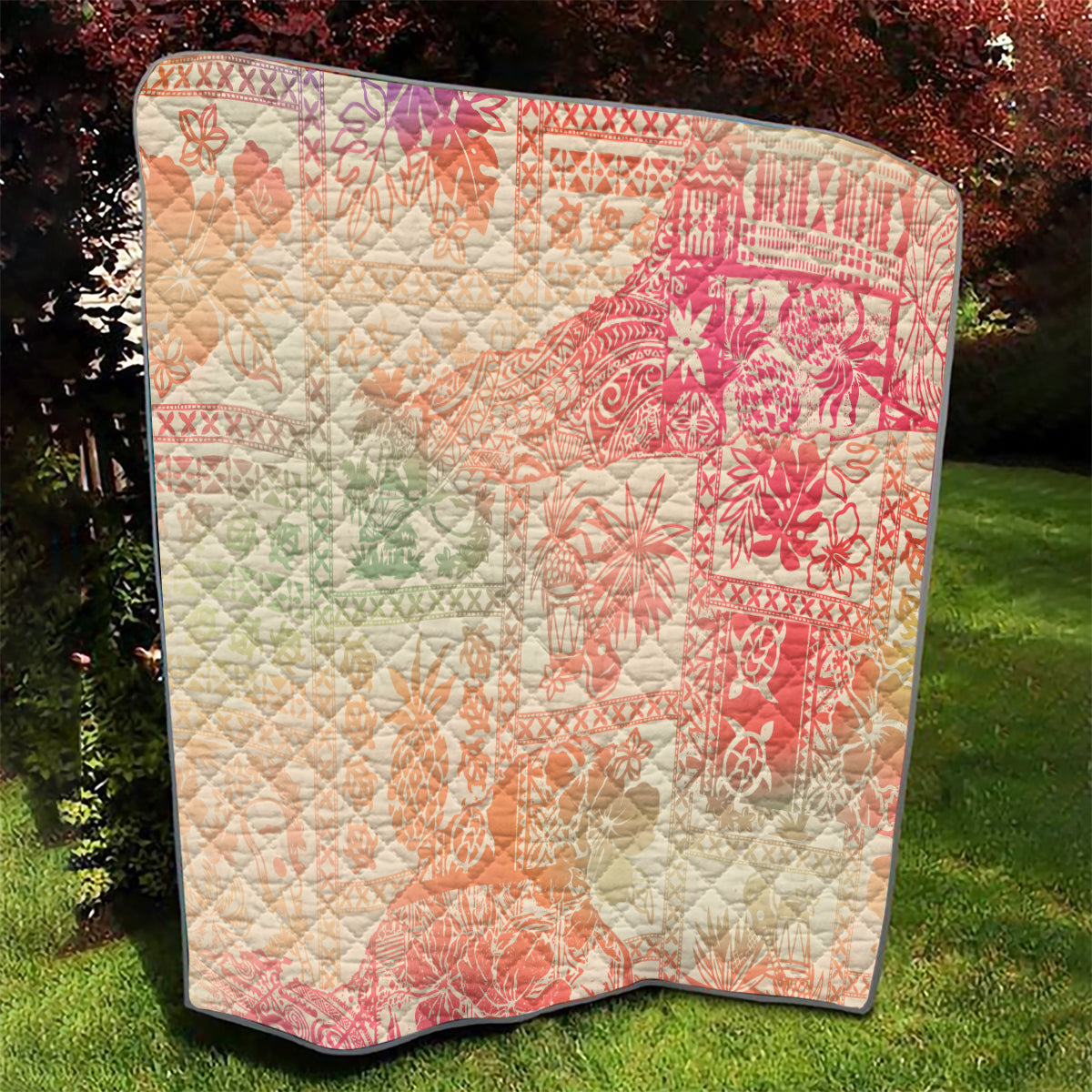 Hawaiian quilt blanket with coral-pink and cream ombre tribal floral print and diamond stitching