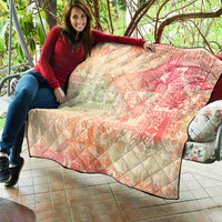 Hawaiian quilt blanket spread over seating, pink-red and cream ombre tribal floral pattern, quilted