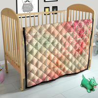 Hawaiian quilt blanket in wooden crib, pink-to-cream ombre tribal floral pattern with black trim