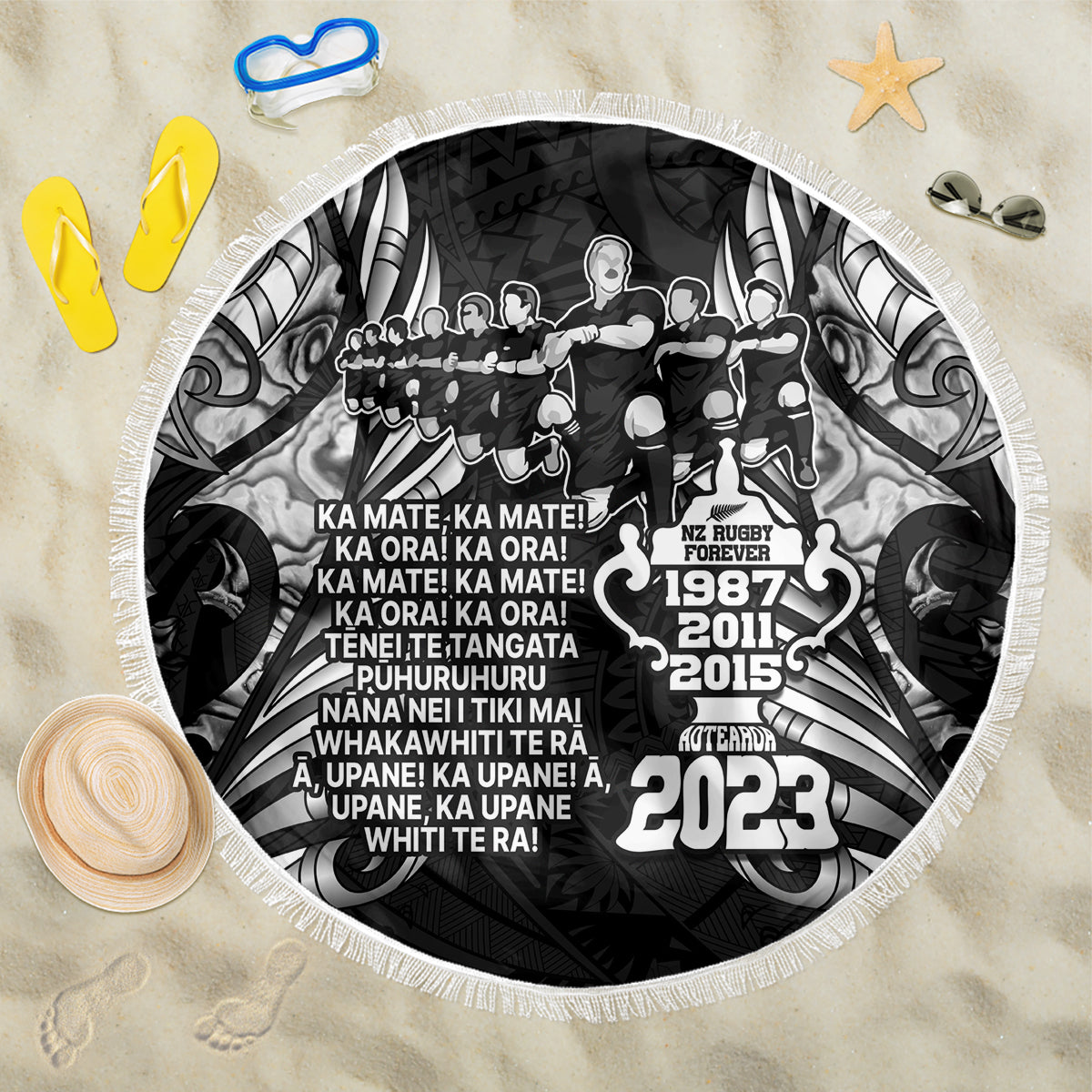 Black round beach blanket with white fringe, rugby haka graphic and 2023 print
