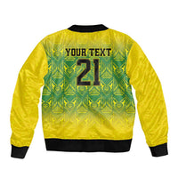 Gold bomber jacket back with green tribal pattern and black ribbed hem, zip-up