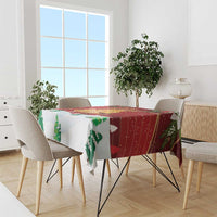 Red Christmas tablecloth on dining table with pine-tree accents and colorful stripe pattern