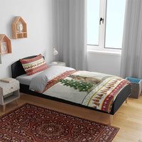 Christmas bedding set on bed: white comforter with red border, dog in scarf, pine tree center print