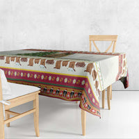 Red-trimmed cow themed Christmas tablecloth draped over table edge