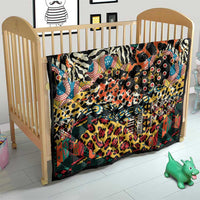 Wild animal skins quilt on a crib with zebra and spotted patterns in multicolors