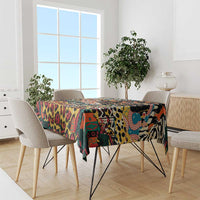 Black wild animal pattern tablecloth draped over dining table with colorful artwork