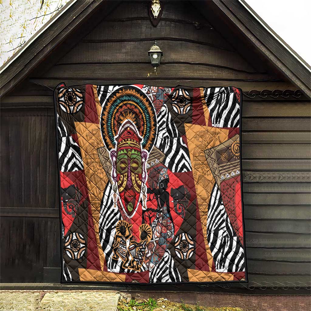 African motif quilt hanging on barn wall with zebra stripes and central colorful face motif.