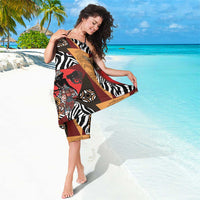 Tribal-pattern sarong wrap with zebra stripes and face motifs in black, tan, red, and gold