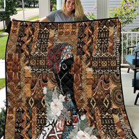 Brown tribal quilt with geometric pattern, black face figure, floral applique, black border