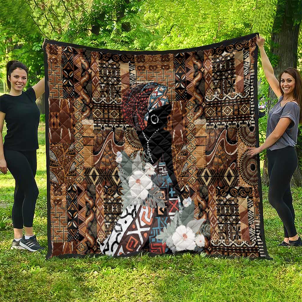 Brown African-inspired quilt blanket with bold geometric design, face graphic, white floral