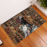 Brown rubber doormat in corner, tribal design with black woman silhouette and white flowers