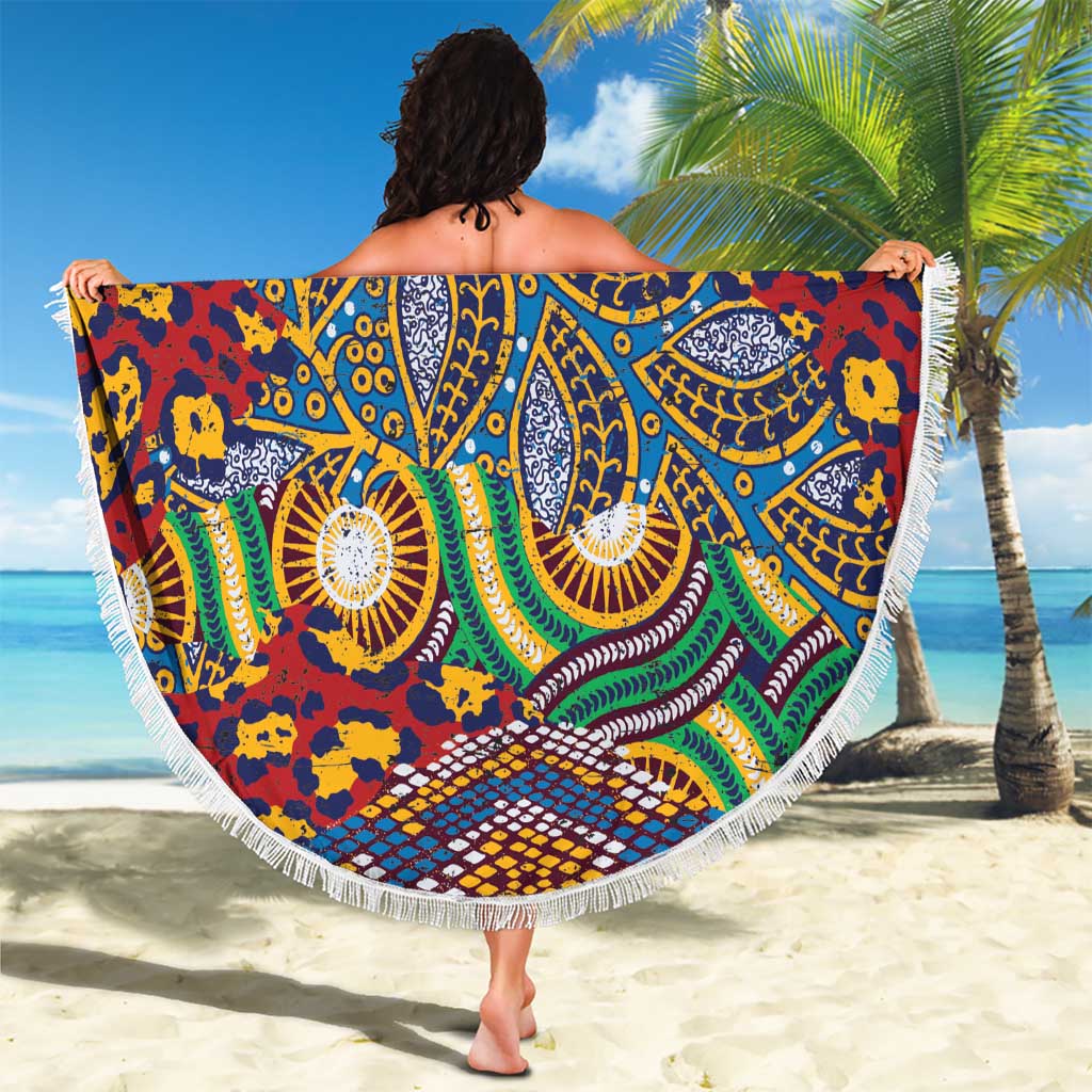 Round beach blanket held up, fringed edge, vibrant African animal-skin pattern in blue and red