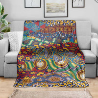 Multicolor animal-skin pattern blanket spread on a gray sofa, featuring teal and gold accents