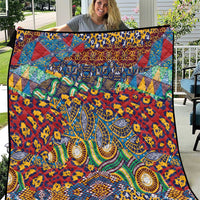 Colorful patterned quilt with ornate animal-skin motifs in red, blue, and green.