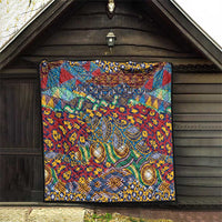 Square quilt hung on a porch wall, with red, blue, and green animal-skin pattern and trim.