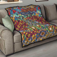 Patterned quilt folded on a sofa, featuring ornate animal-skin design in red, blue, and gold.
