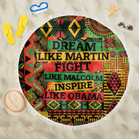 Round beach blanket with white fringe and colorful “DREAM LIKE MARTIN…” text