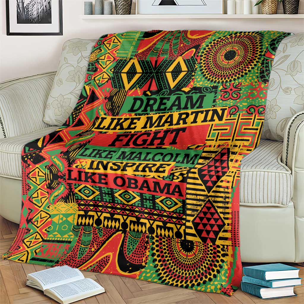 Patterned throw blanket spread on couch with multicolor text and symbols
