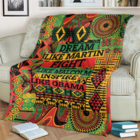 Patterned throw blanket spread on couch with multicolor text and symbols