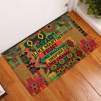 Rectangular patterned doormat in green and red with quote text inside a central frame
