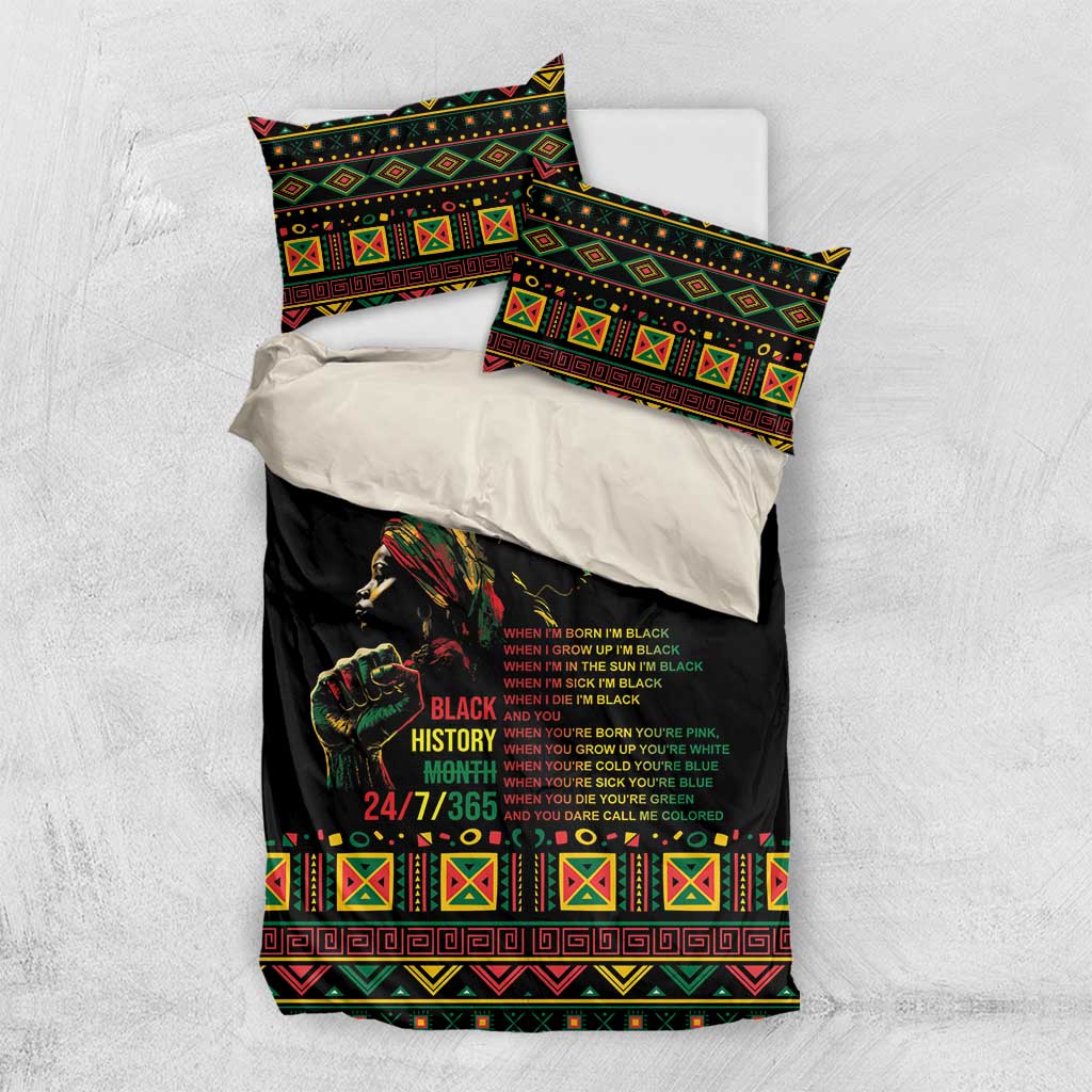 Black bedding set laid out with duvet and pillowcases featuring tribal geometric trim