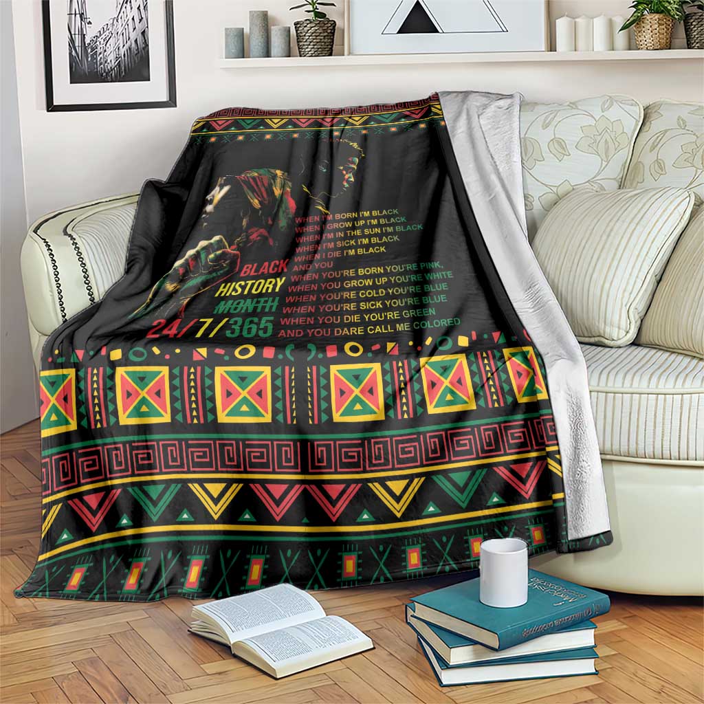Black history blanket with colorful patterned border and portrait graphic, draped over couch