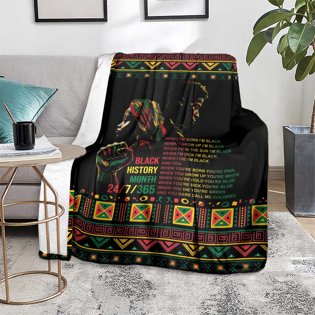 Black history blanket with colorful border and text, laid over seat with books nearby