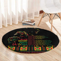Black round rug with colorful face graphic, multiple text lines, and geometric border