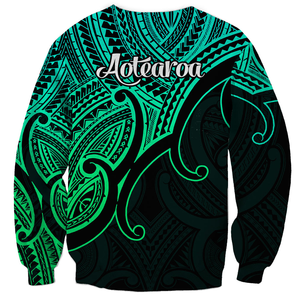 Green unisex sweatshirt back with Aotearoa script and tribal koru print