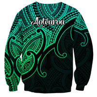 Green unisex sweatshirt back with Aotearoa script and tribal koru print