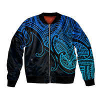 Blue bomber jacket with black zip, Maori-style koru tribal pattern and ribbed cuffs