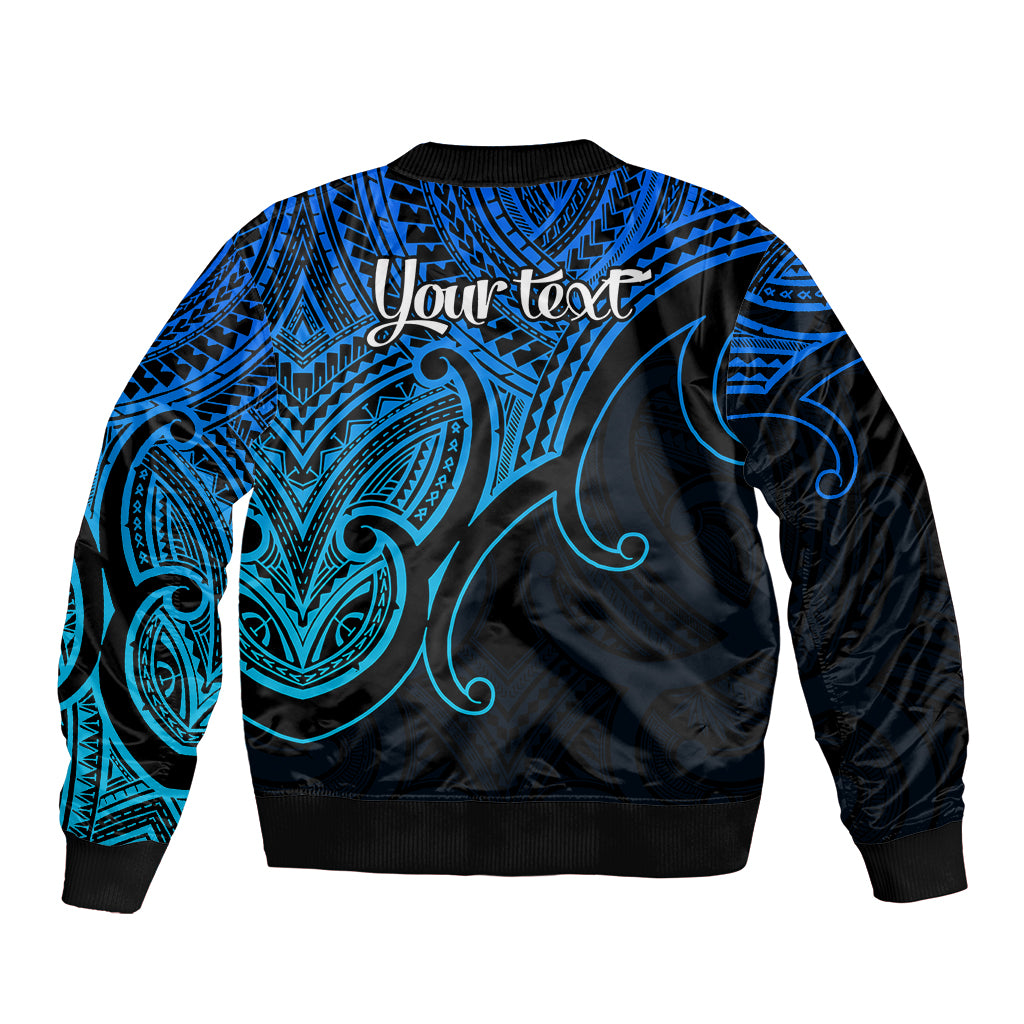 Back of blue bomber jacket with black ribbed hem, Maori-style tribal pattern and 'Your text'
