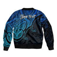 Back of blue bomber jacket with black ribbed hem, Maori-style tribal pattern and 'Your text'