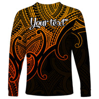 Long sleeve shirt with koru-style pattern in gold, orange, and black, crew neck