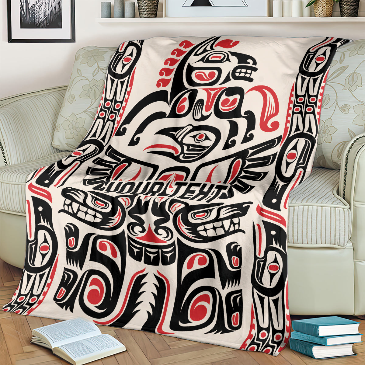 Haida-style throw blanket draped on couch, red/black/white pattern with 'YOUR TEXT'