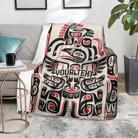 Haida-style throw blanket on gray sofa with red/black/white pattern and 'YOUR TEXT'