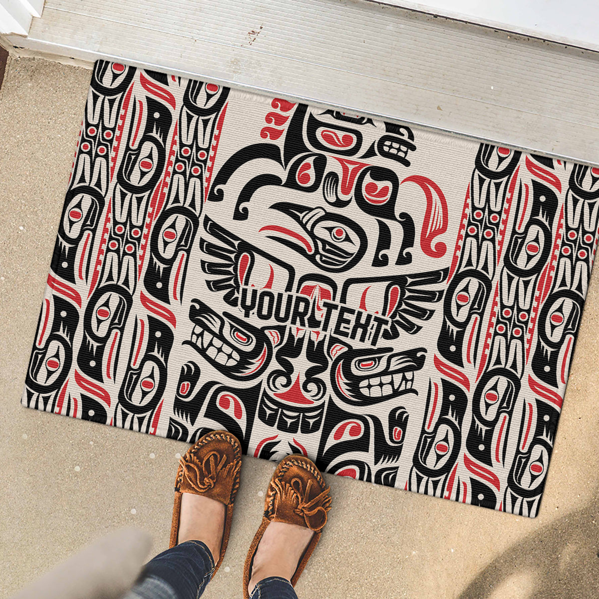Personalized rubber doormat on patio with Haida raven and totem pattern, black red white.