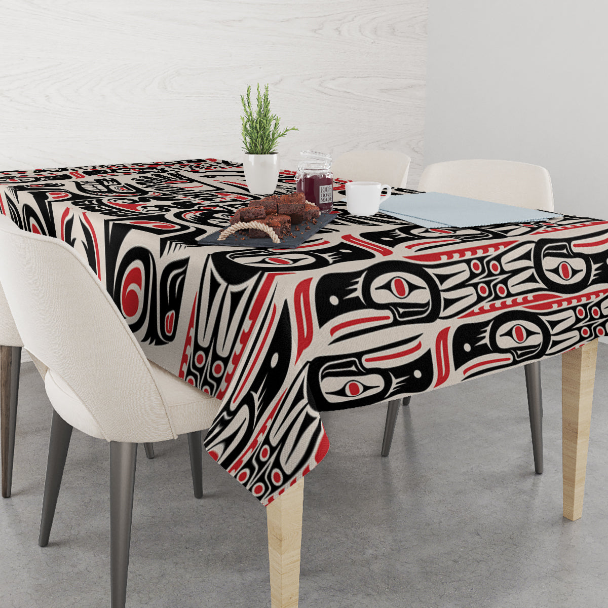 Personalized tablecloth on table with bold black and red Haida-style graphic pattern