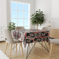 Personalized tablecloth draped over dining table; black and red Haida-style motif