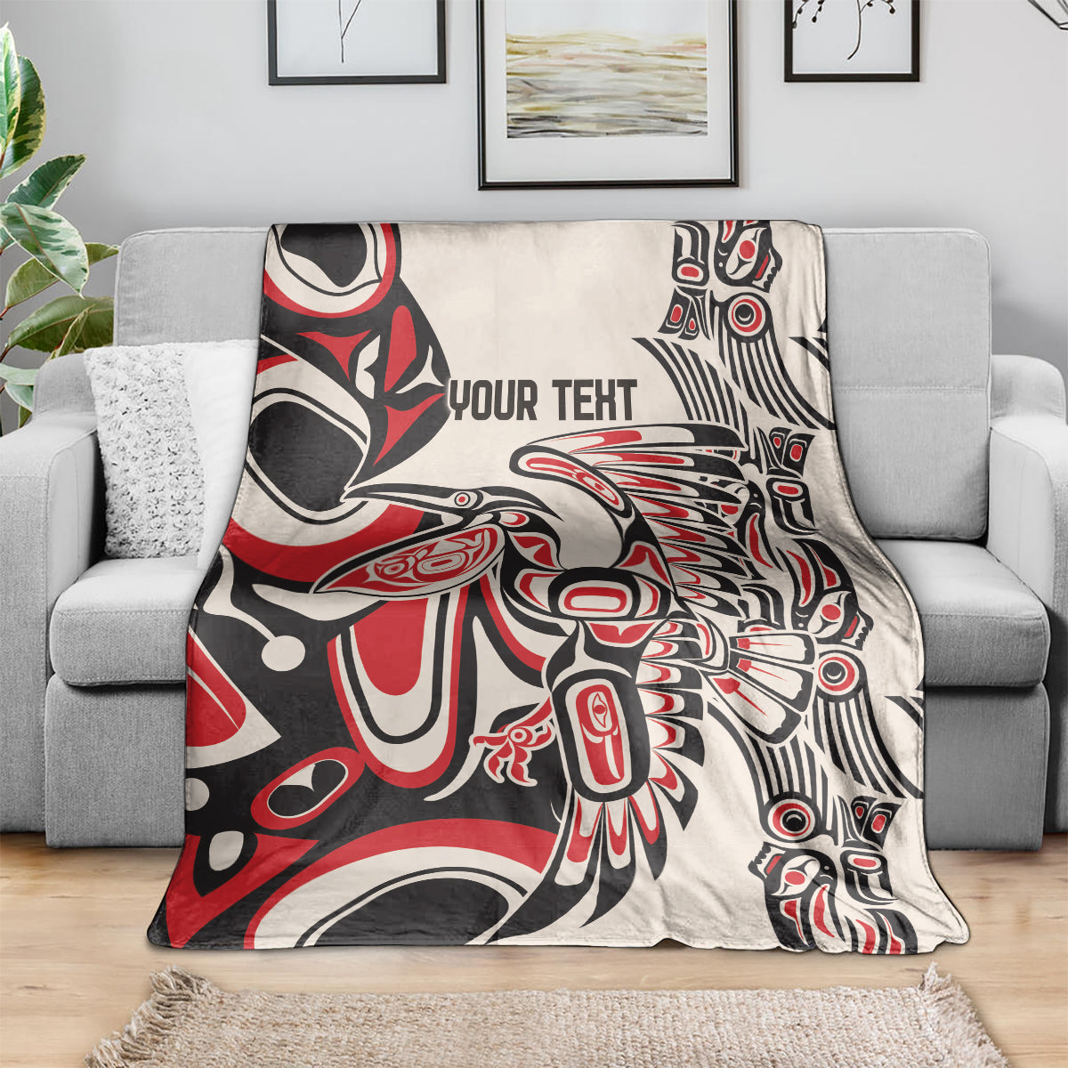 Personalized throw blanket on gray couch, red/black/white abstract design with 'YOUR TEXT'