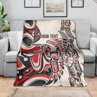 Personalized throw blanket on gray couch, red/black/white abstract design with 'YOUR TEXT'
