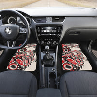 Car interior with two front floor mats featuring red/black/white tribal pattern