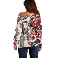 Off-shoulder sweater back in red, black and white with large central tribal motif